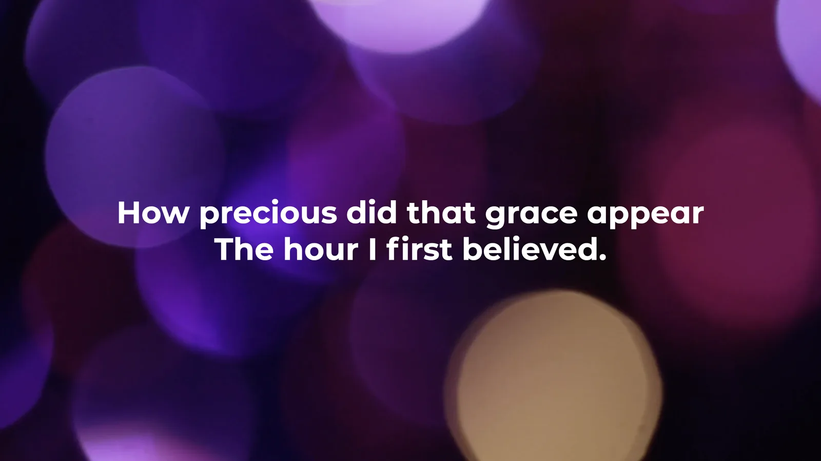 A verse of Amazing Grace on the main screen, white words over a slow-moving violet background.